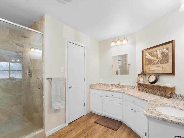 bathroom with a shower with door, vanity, and wood-type flooring