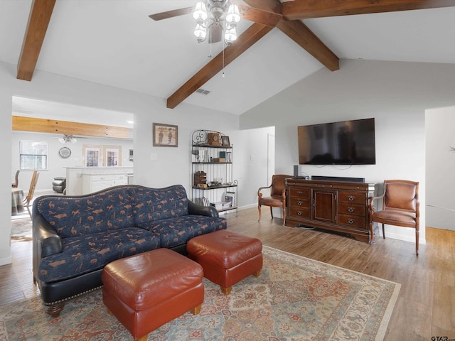 living room featuring light wood-type flooring, lofted ceiling with beams, and ceiling fan