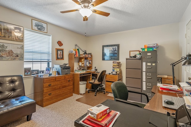 carpeted home office with ceiling fan and a textured ceiling