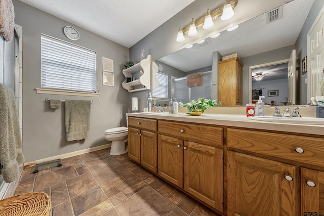 bathroom featuring vanity, toilet, a textured ceiling, and an enclosed shower