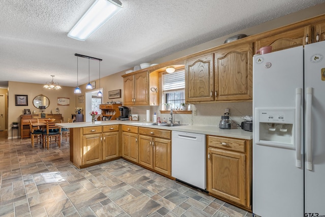 kitchen featuring kitchen peninsula, hanging light fixtures, sink, white appliances, and a textured ceiling