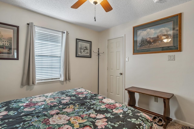 carpeted bedroom with ceiling fan and a textured ceiling