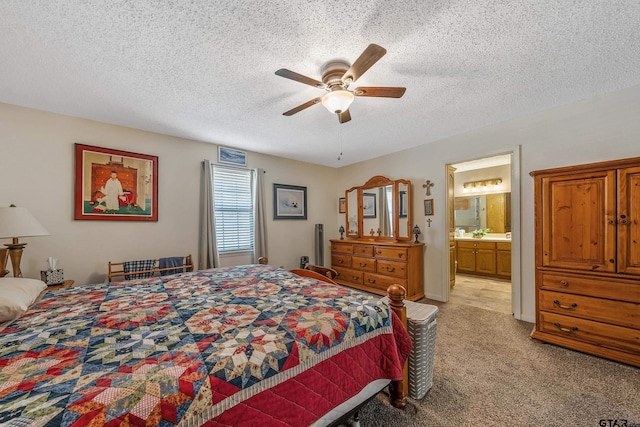 carpeted bedroom featuring ceiling fan, a textured ceiling, and ensuite bathroom