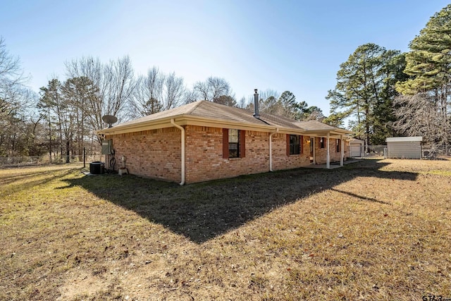 view of side of property featuring a lawn and a storage shed