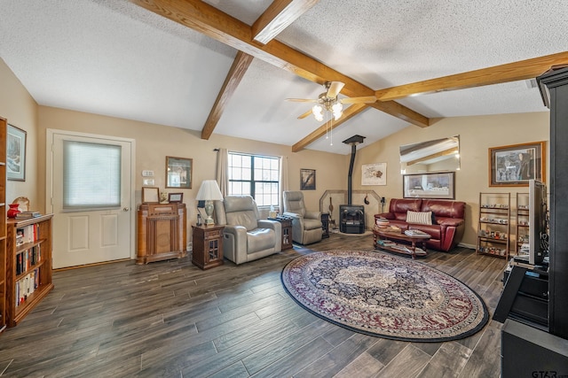 living room featuring ceiling fan, a wood stove, a textured ceiling, and vaulted ceiling with beams