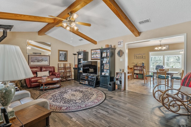 living room with ceiling fan with notable chandelier, vaulted ceiling with beams, a textured ceiling, and dark hardwood / wood-style flooring