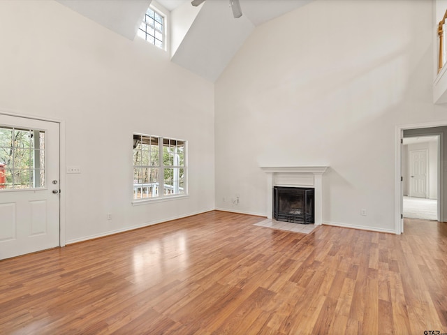 221 Butternut Gln, Holly Lake Ranch, TX 75765 - unfurnished living room featuring high vaulted ceiling, ceiling fan, light wood finished floors, a fireplace with flush hearth, and baseboards