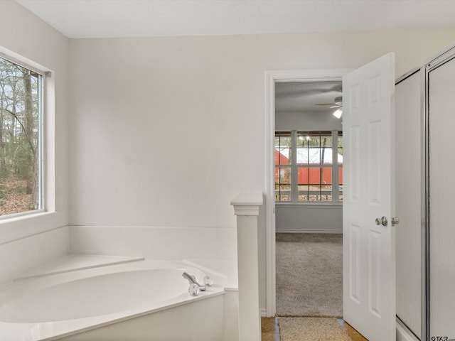 221 Butternut Gln, Holly Lake Ranch, TX 75765 - full bathroom featuring healthy amount of natural light, a bath, and a ceiling fan