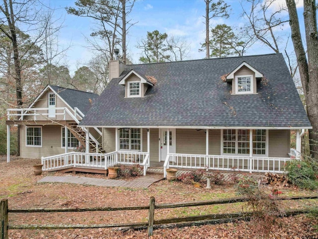 221 Butternut Gln, Holly Lake Ranch, TX 75765 - view of front facade featuring covered porch, a chimney, a shingled roof, and fence