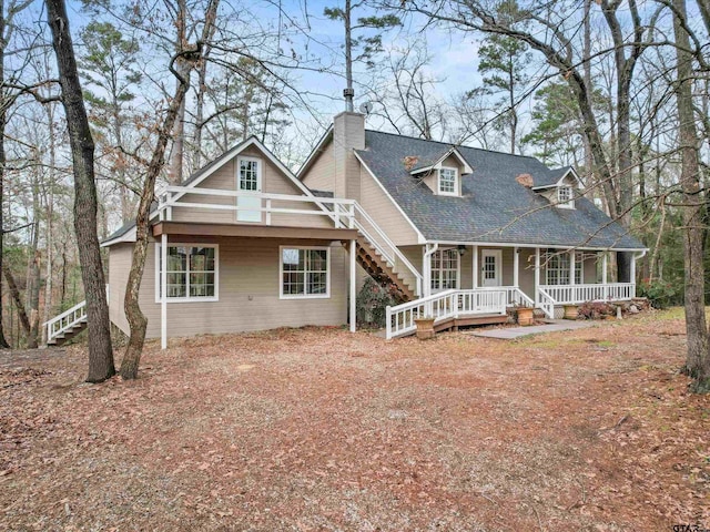 221 Butternut Gln, Holly Lake Ranch, TX 75765 - view of front of home with covered porch, stairway, a chimney, and roof with shingles