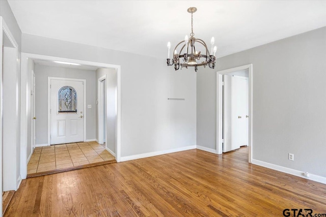 foyer entrance featuring hardwood / wood-style floors and an inviting chandelier