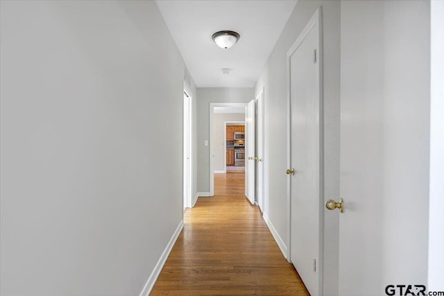 corridor with hardwood / wood-style floors