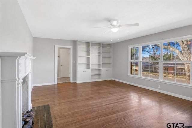 unfurnished living room featuring ceiling fan and dark hardwood / wood-style flooring