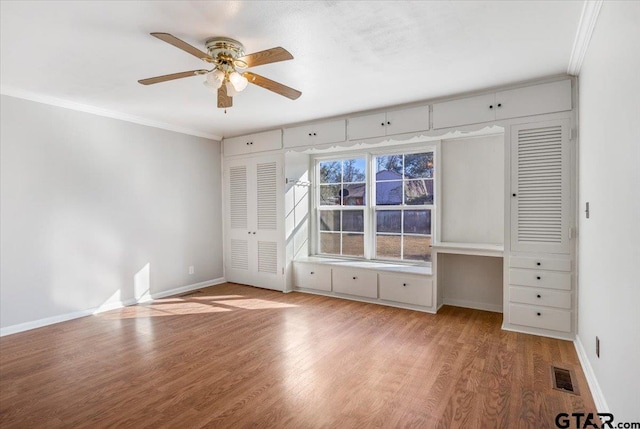 unfurnished bedroom featuring wood-type flooring, ceiling fan, and crown molding