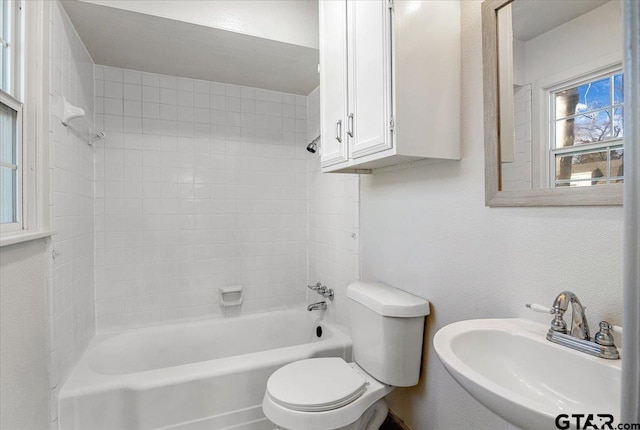 full bathroom featuring toilet, tiled shower / bath combo, and sink