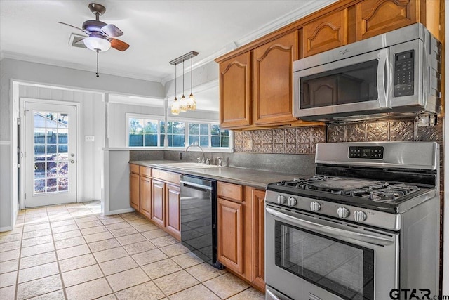 kitchen with ornamental molding, appliances with stainless steel finishes, sink, and a healthy amount of sunlight