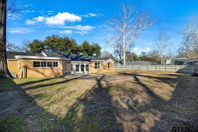 rear view of property with a lawn