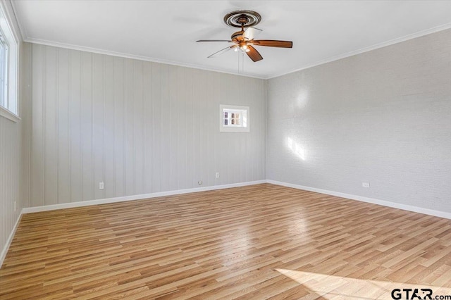 empty room with ceiling fan, crown molding, and light hardwood / wood-style floors