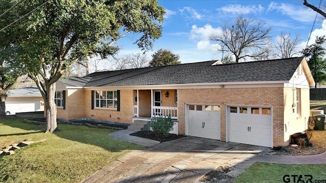 single story home with a garage, a front yard, and a porch