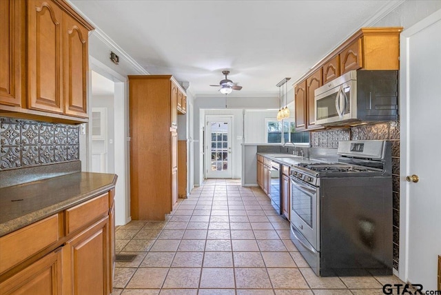 kitchen with sink, crown molding, ceiling fan, stainless steel appliances, and tasteful backsplash