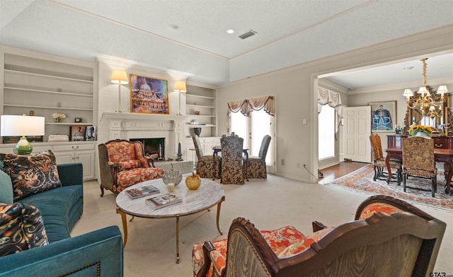 carpeted living area with visible vents, baseboards, a chandelier, built in shelves, and a fireplace