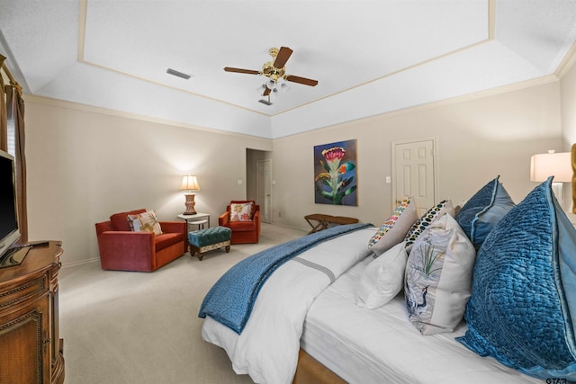 bedroom with a ceiling fan, carpet floors, a tray ceiling, ornamental molding, and visible vents