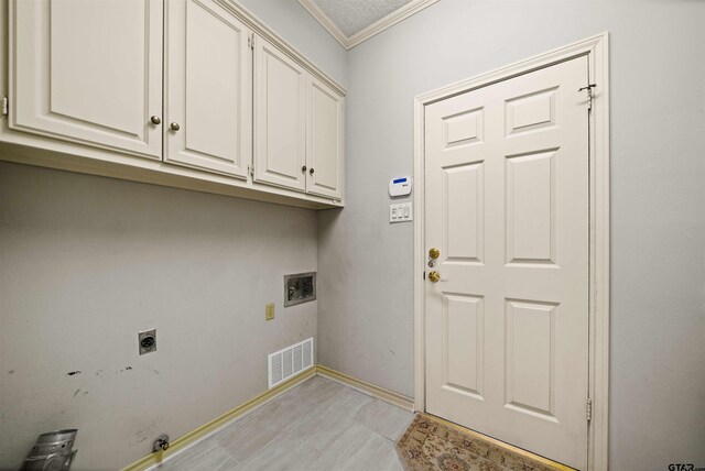 washroom featuring electric dryer hookup, cabinet space, baseboards, ornamental molding, and visible vents
