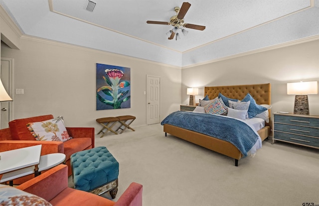 bedroom featuring a tray ceiling, visible vents, a ceiling fan, crown molding, and carpet floors