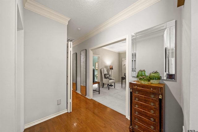 hall featuring baseboards, ornamental molding, and wood finished floors