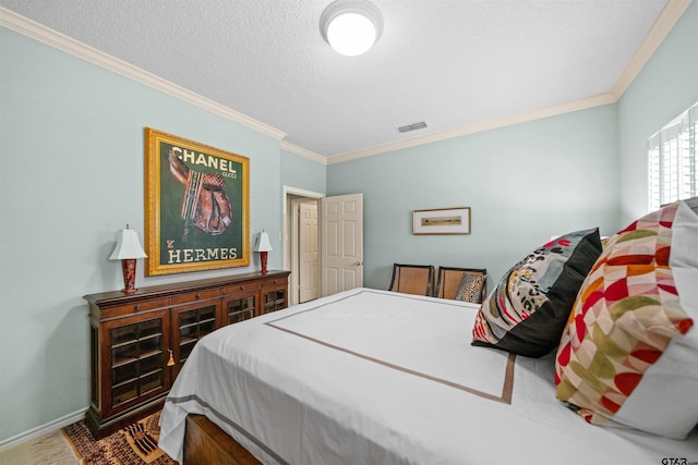 bedroom with baseboards, crown molding, a textured ceiling, and visible vents