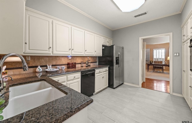kitchen with a sink, stainless steel fridge with ice dispenser, backsplash, black dishwasher, and visible vents