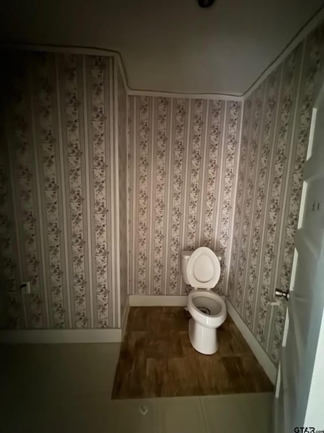 bathroom with toilet and baseboards