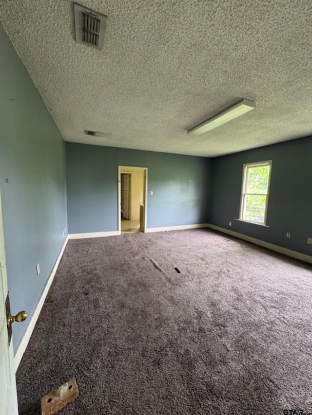 empty room featuring visible vents, a textured ceiling, baseboards, and carpet floors