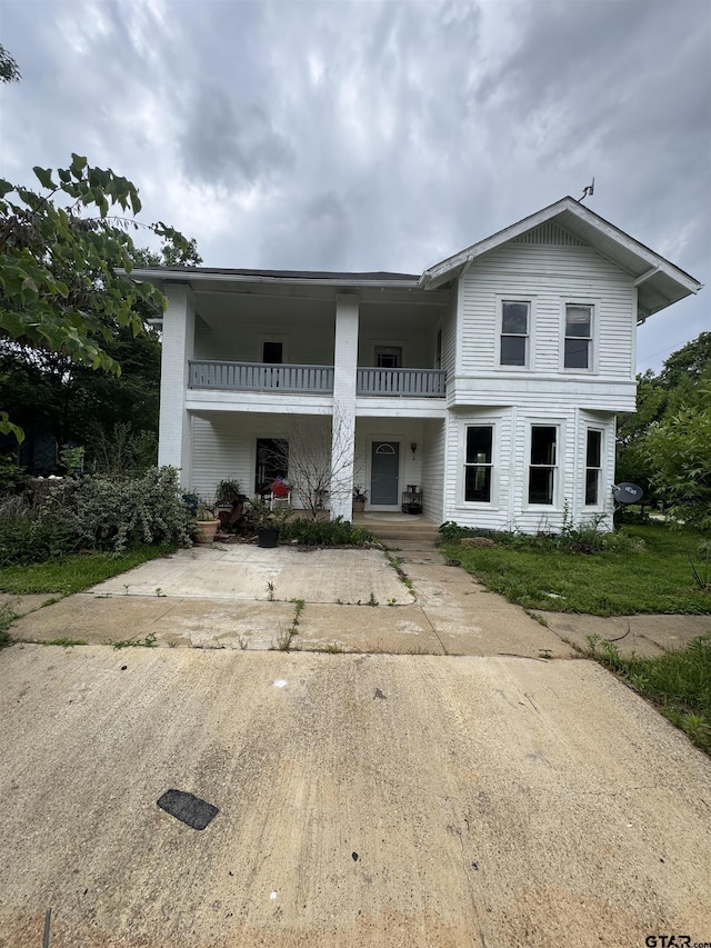 view of front of property featuring a balcony and covered porch