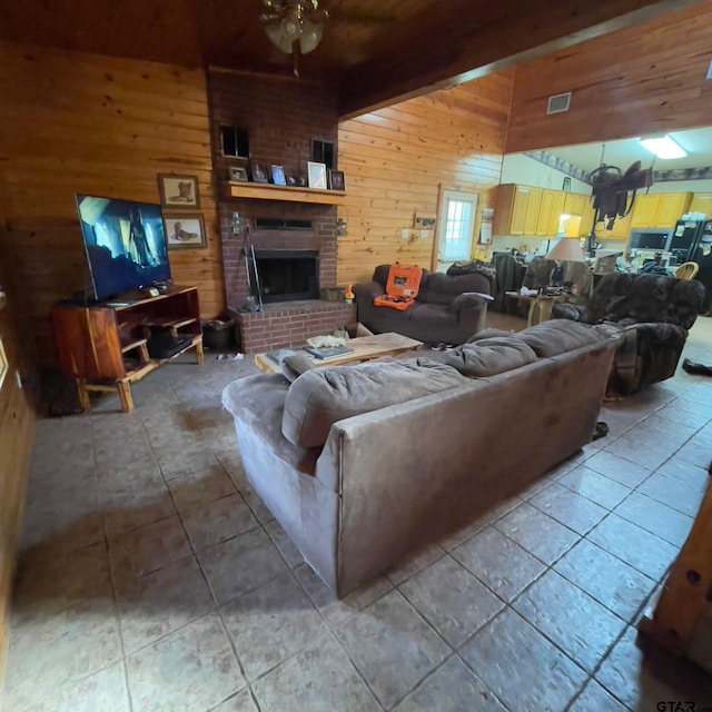 living room with tile patterned floors, a brick fireplace, ceiling fan, and wooden walls