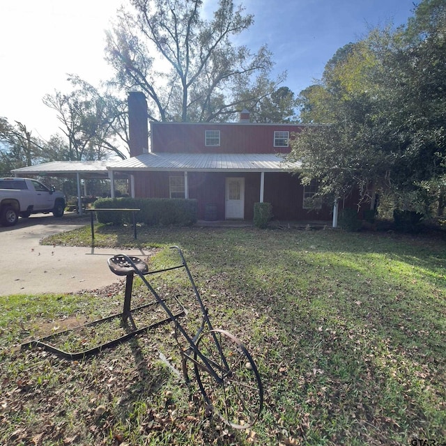 back of property featuring a carport and a lawn