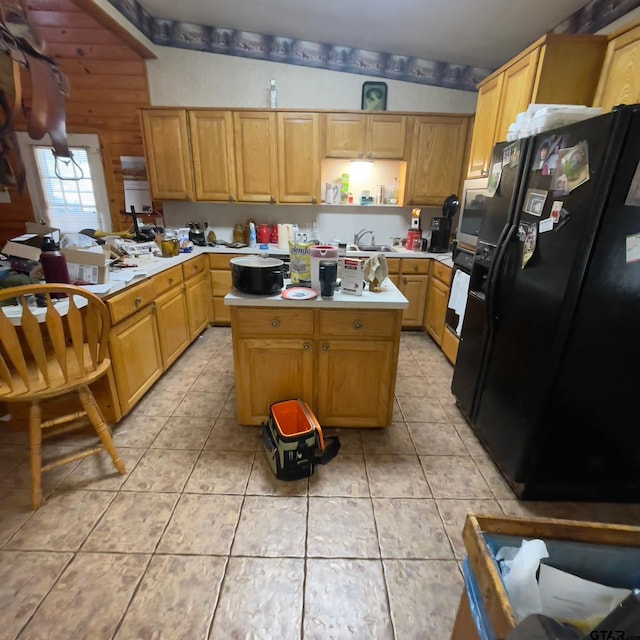 kitchen with vaulted ceiling with beams, a center island, light tile patterned floors, and black appliances