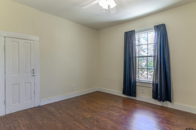 empty room with ceiling fan and dark hardwood / wood-style flooring