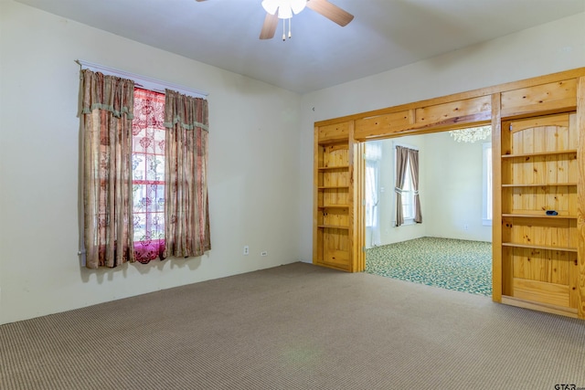 carpeted empty room featuring ceiling fan and plenty of natural light