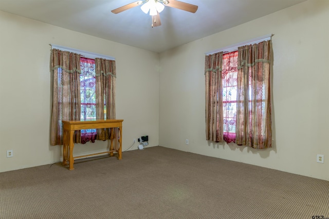 carpeted spare room featuring ceiling fan