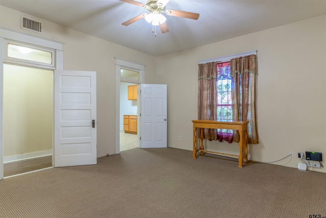 interior space with ceiling fan and light colored carpet