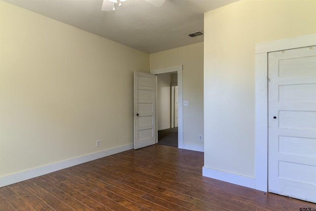 empty room featuring ceiling fan and dark wood-type flooring