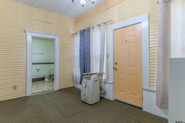 foyer entrance with wooden walls