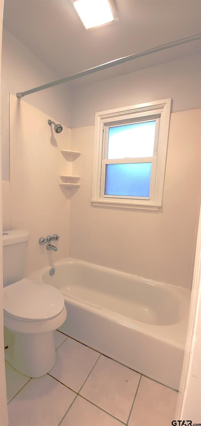 bathroom featuring toilet, tile patterned flooring, and bathing tub / shower combination