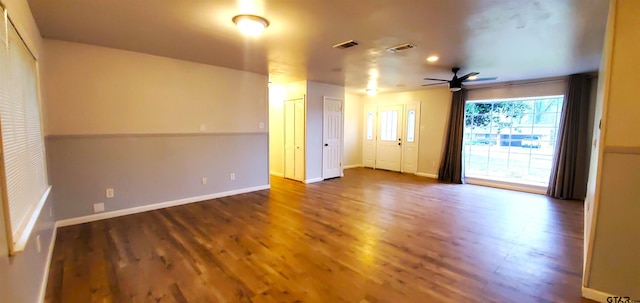 empty room featuring a ceiling fan, baseboards, visible vents, and wood finished floors