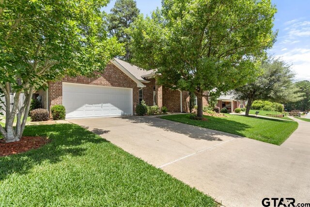 9190 Teal Flight Way, Tyler, TX 75703 - obstructed view of property with driveway, brick siding, a front lawn, and a garage