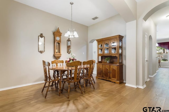 9190 Teal Flight Way, Tyler, TX 75703 - dining room with arched walkways, light wood-style floors, baseboards, and a chandelier