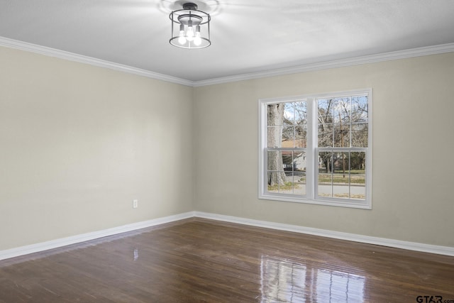 spare room with crown molding, dark hardwood / wood-style flooring, and a chandelier