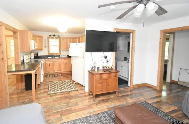 1611 County Road 1858, Yantis, TX 75497 - kitchen featuring white appliances, dark countertops, light brown cabinets, and light wood-type flooring