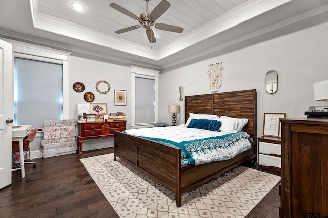 bedroom featuring ceiling fan, dark wood-type flooring, and a raised ceiling